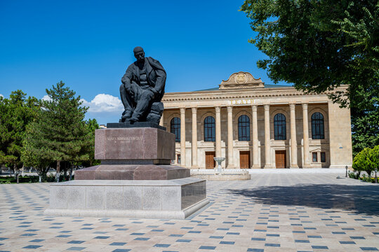 Nakhchivan State Musical Dramatic Theatre features a statue in front with clear blue sky in the background