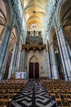 Inside the Cathedral of Amiens with wooden chairs and tall arches, showcasing its architectural beauty in France