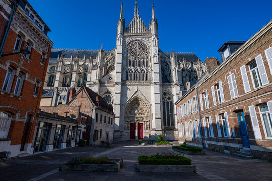 Cathedral of Amiens stands tall amid buildings under clear sky in France