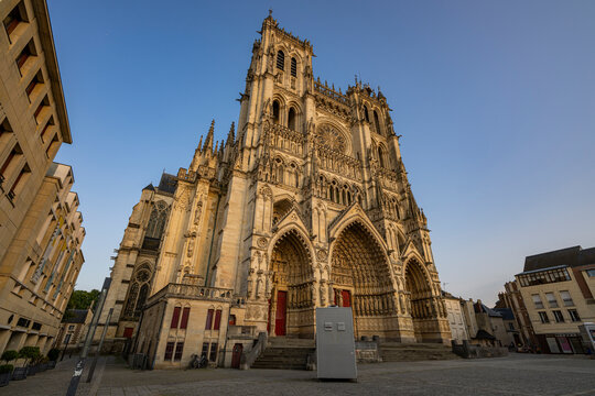 Cathedral of Amiens showcases detailed architecture in evening light near a quiet square in France