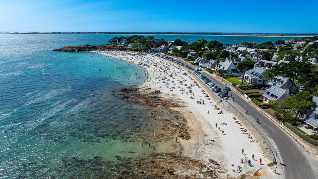 View of Legenese cove beach with sunbathers and clear water in Carnac, Brittany, France during a sunny day