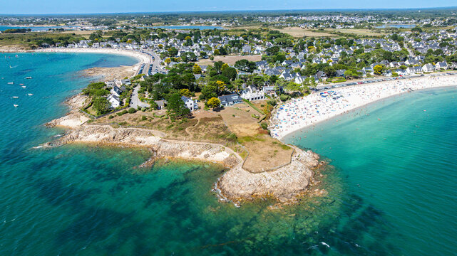View of Legenese cove beach and surrounding area in Brittany, France showing boats and people enjoying the coast during daytime