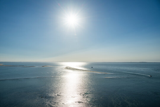 Sunlight reflects on the ocean surface near the lighthouse of Cordouan in France during the daylight hours