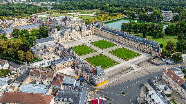 Aerial view showing the architecture and gardens of Fontainebleau palace in France with surrounding landscape