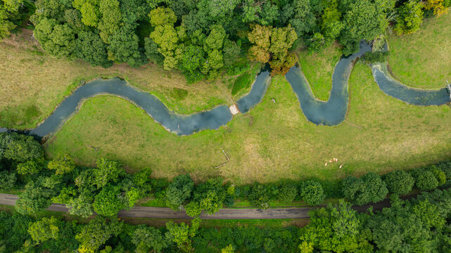 Snaking river winds through lush greenery near the Abbey of Fontenay in France