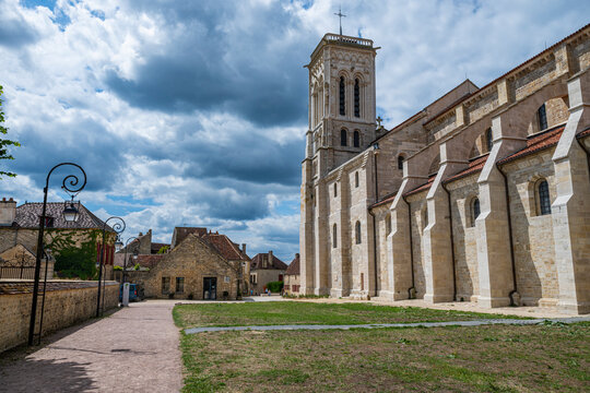 Vezelay Abbey and surrounding buildings under a cloudy sky in France