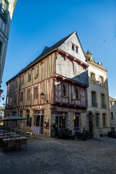 Historic building with timber framing and outdoor seating area in a French town on a sunny day
