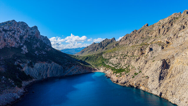 Views of turquoise waters in the secluded vale Boquer on the coast of Mallorca, capturing the rugged terrain and clear skies
