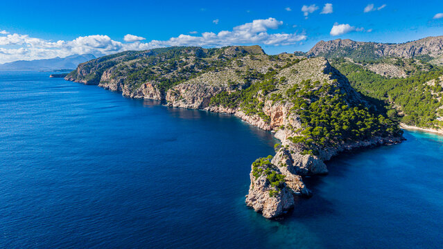 Aerial view showcases Formentor peninsula in Mallorca surrounded by blue water and green landscapes in the Balearic islands of Spain