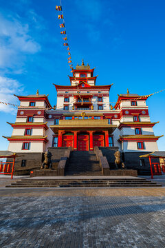 Buddhist monastery Thubten Shedrub Ling with colorful flags and blue sky in Kyzyl Russia