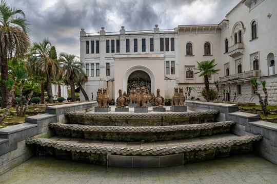 Visitors explore the F.A. Iskander Russian Drama Theater and its surrounding area in Sukhumi, Abkhazia on an overcast day