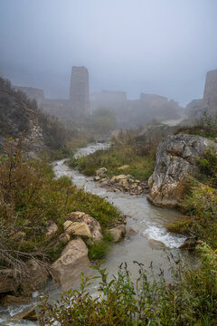 Abandoned buildings and creek in Kamunta village shrouded in fog in North Ossetia, Russia