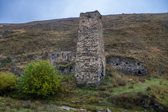 Ruins of Kamunta village stand alone in the Caucasus mountains of North Ossetia, Russia under a cloudy sky
