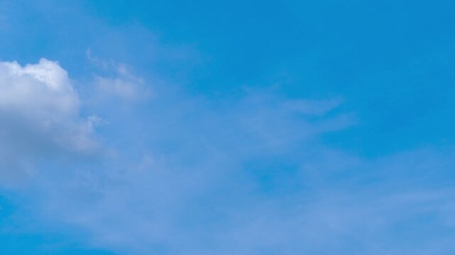 Timelapse of white cumulus clouds drifting across bright blue sky.  Fluffy clouds dynamically change their shape on sunny day. Nature background. 4K time lapse footage.