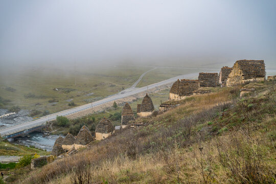 Exploring a historic burial site in Dargavs surrounded by fog in the Caucasus mountains of North Ossetia, Russia