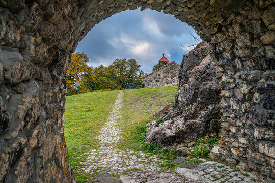 Entrance gate leading to St. George Church in South Ossetia, Russia with a stone path and trees