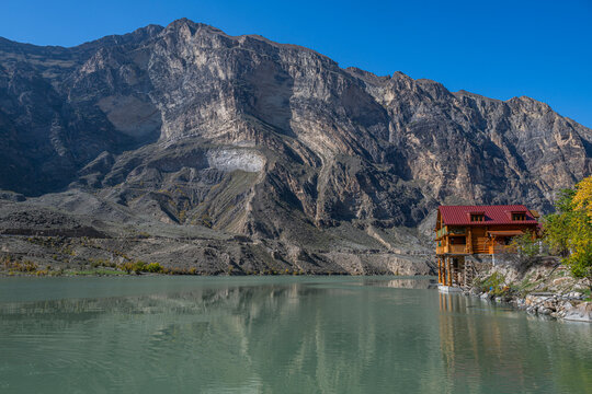 Mountain lodge situated by the Awarskoje Koisu river in Dagestan, Russia near rocky mountain landscape and clear blue sky