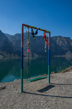 Swing set by the river with flowers and mountains in the background near Dagestan, Russia