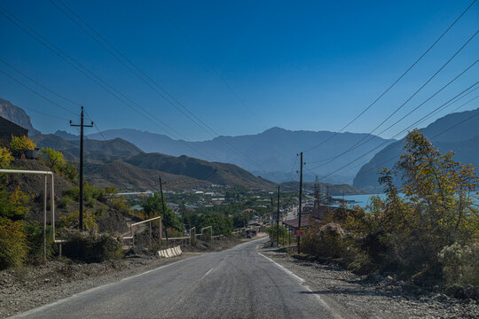 Road along Awarskoje Koisu river in Dagestan, Russia shows landscape of mountains and river under clear sky