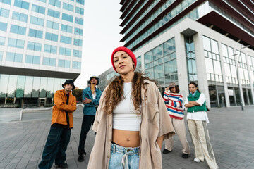 Fototapeta na wymiar Young trendy female influencer woman posing with friends in modern urban city after video dance