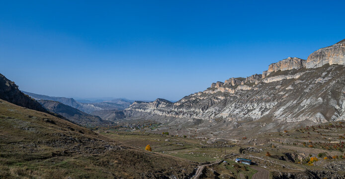 Explore the mountain valley landscape near Kubachi in Dagestan, Russia with its unique terrain and geographical features amidst clear skies