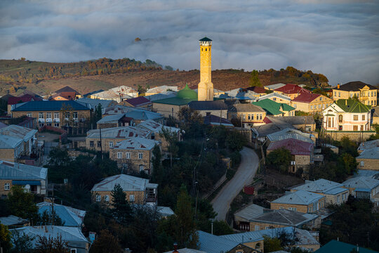 Overlook of Kubachi town in Dagestan with a view of houses and a tower among mist