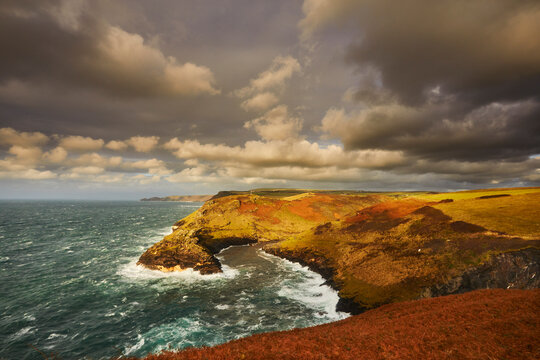 Evening sunlight illuminates cliffs at Boscastle harbour on the Atlantic coast in Cornwall, Great Britain