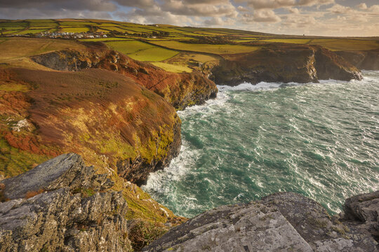 Sunlight shines on cliffs near Boscastle from Willapark headland on the Atlantic coast of Cornwall in Great Britain