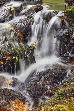 Waters flow over rocks in the Dart Valley near Dartmeet in Dartmoor National Park during autumn in Devon, Great Britain