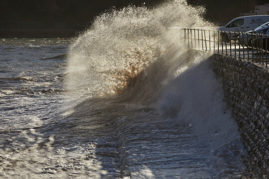 Waves crash against the sea wall as the tide rises along the coast of the English Channel at Teignmouth in Devon