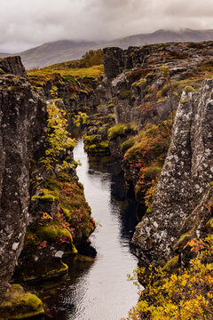 Clear blue water flows through volcanic rock in Silfra fissure at Thingvellir National Park in autumn