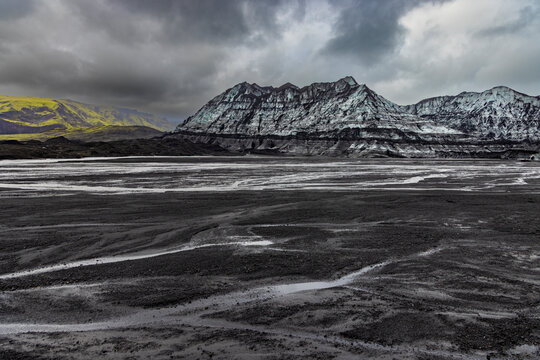 Glacial meltwater patterns interact with volcanic plains near Katla glacier in Iceland displaying changes in the landscape