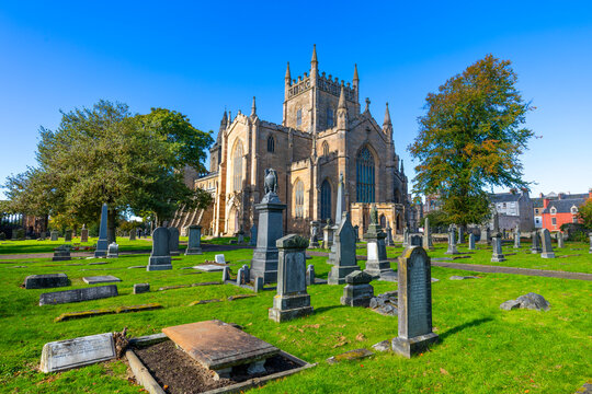 Dunfermline Abbey with gravestones under blue sky in Dunfermline, Fife, Scotland