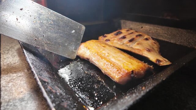 Flounder and cutlassfish grilling on hot iron plate