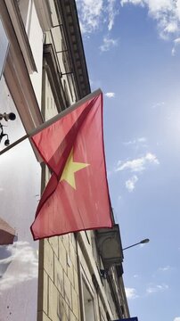 Vietnam Flag In Urban Setting. Flag Of Vietnam Waves Over Ancient Building In Peaceful Street Scene