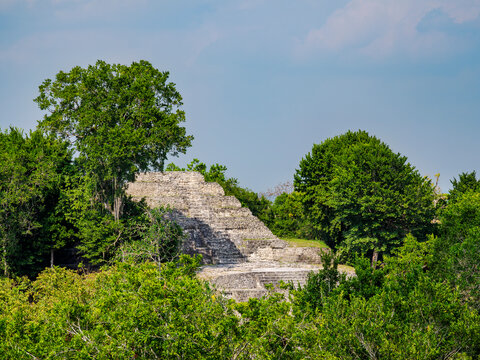 View of North Acropolis at Yaxha Archaeological Site in Guatemala surrounded by green vegetation and trees