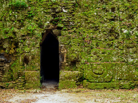 Exploring the entrance of Group G at Acanaladuras Palace in Tikal, Guatemala reveals ancient stonework and lush greenery