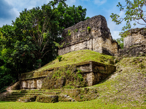 View of Temple of the Skulls from the back in Tikal, Guatemala during a bright day with blue sky and green vegetation