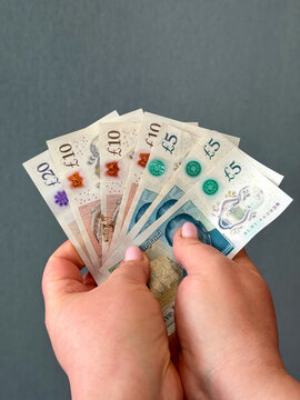 Display of British currency notes held in two hands