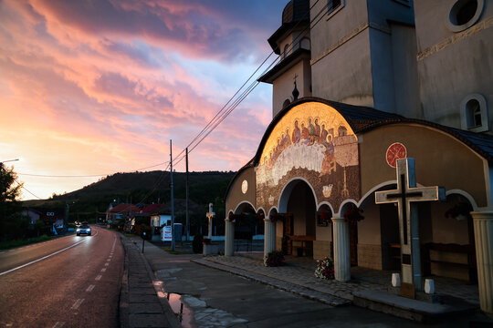 Sunset shines on orthodox church with mosaic in Romania
