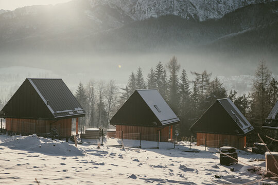 Winter houses in Zakopane with snow-covered roofs near High Tatras in Poland during the cold season