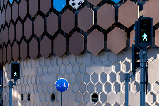 Hexagon pattern facade in Stockholm, Sweden frames traffic lights and a bicycle sign, giving urban architecture a graphic street edge