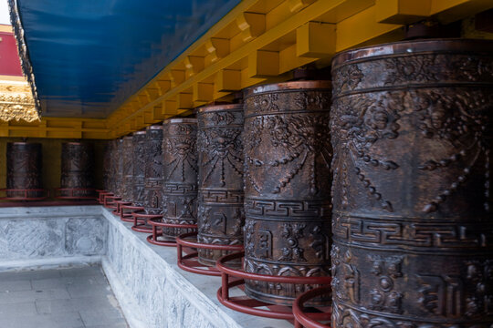 Bronze prayer wheels at Songzanlin Monastery in Shangri-La City represent Buddhist devotion and meditation practice in Yunnan, China