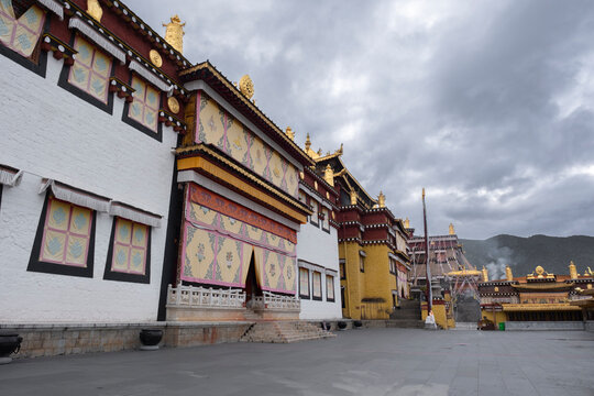 Exterior view of Songzanlin Monastery in Shangri-La City showcasing Tibetan design and mountain clouds
