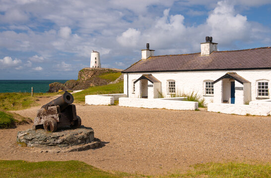 View of pilots cottages and Twr Mawr lighthouse on Llanddwyn Island with cannon near the shore at Anglesey in the United Kingdom