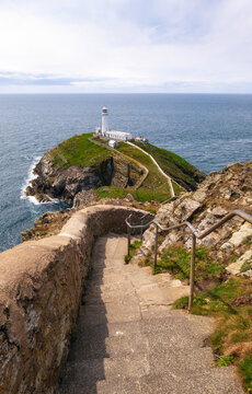 Explore South Stack Lighthouse on Anglesey with its scenic views of the rugged coast and steps leading down to the shore