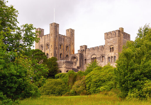 Penrhyn Castle stands amid greenery in Wales showcasing its historic architecture and structure