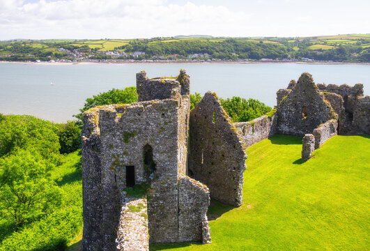 View of Llansteffan Castle ruins with River Tywi and village in the background in Carmarthenshire, Wales
