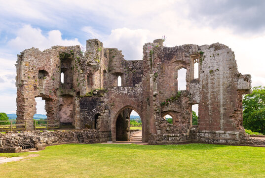 Visitors explore the ruins and historical features of Raglan Castle during a sunny day in Monmouthshire, Wales for a glimpse into the past