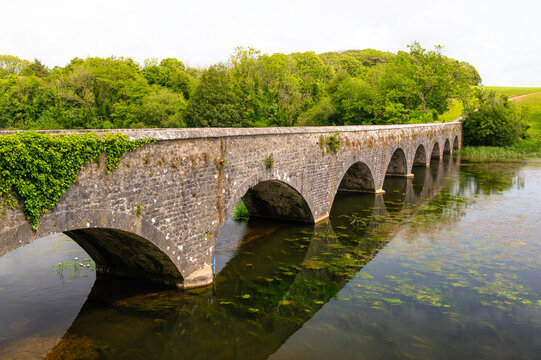 Eight Arch Bridge spans a weir in Bosherston Lily Ponds built in 1797 in Pembrokeshire Wales